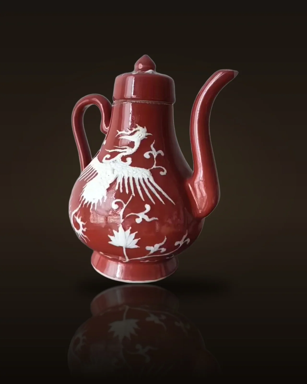 A Rare 'Sacrificial-Red' Glazed Pear-Shaped Ewer with White-Reserve Phoenix and Lotus Design, Xuande Mark